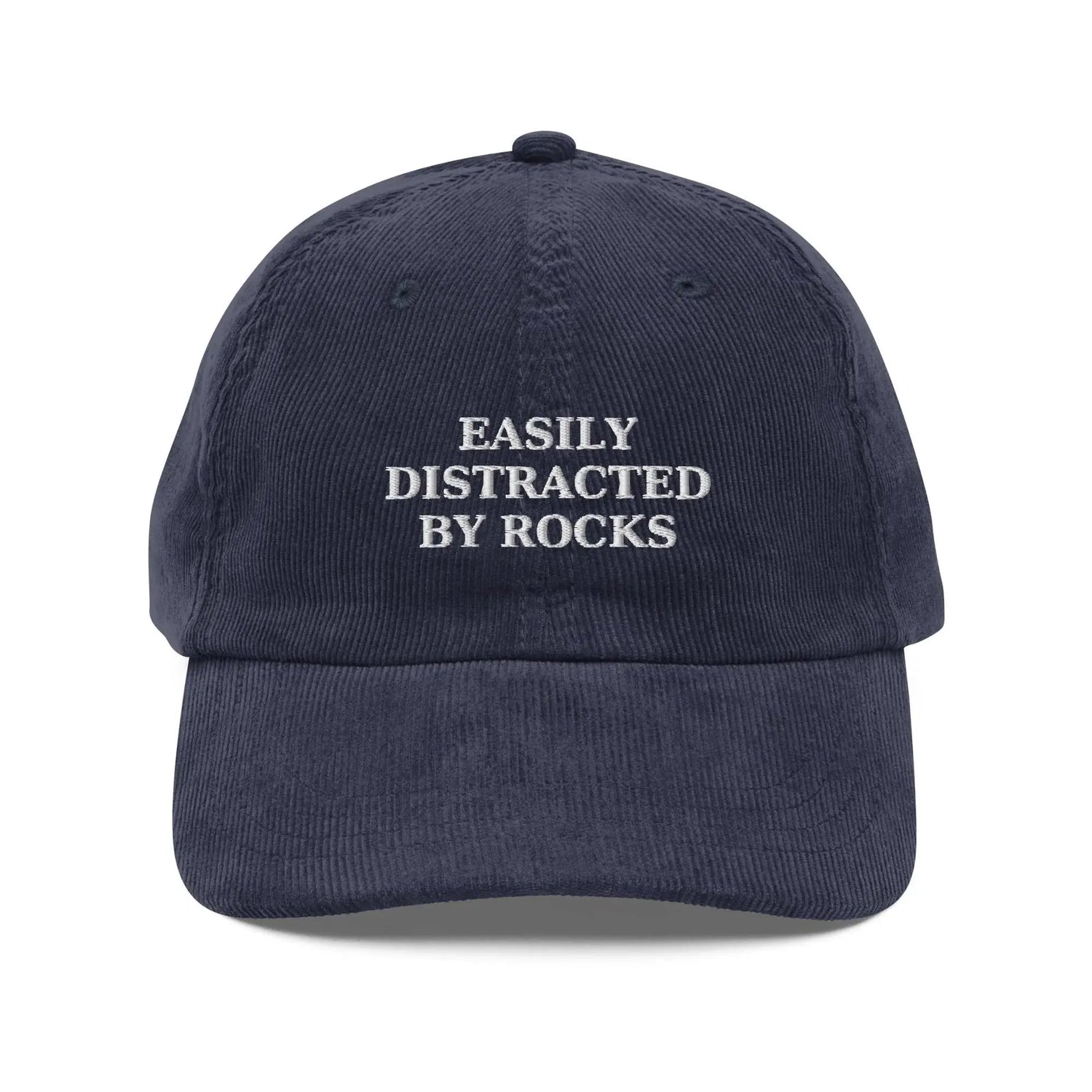 Funny embroidered hat with text “Easily Distracted by Rocks” – navy blue cap from Trini Skies Graphics