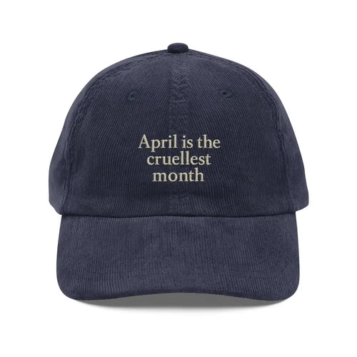 Dark blue corduroy hat with cruellest month embroidery