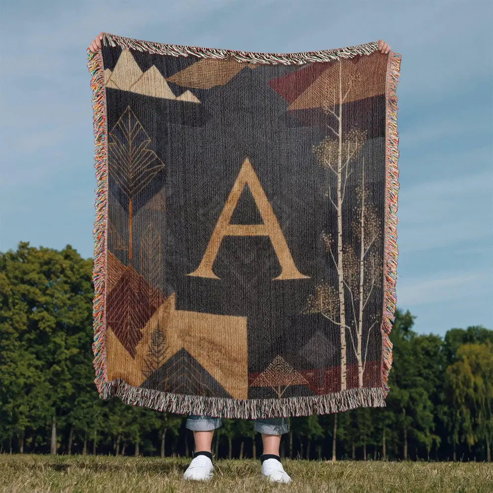 Aspen initial woven blanket with gold A and alpine motifs