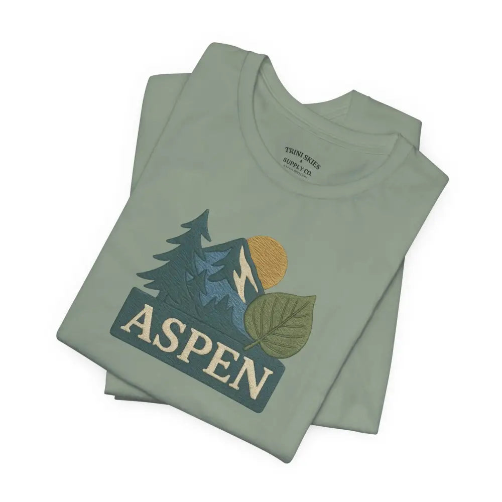 Folded sage green Bella+Canvas Aspen Division tee with detailed DTG embroidered mountain graphic