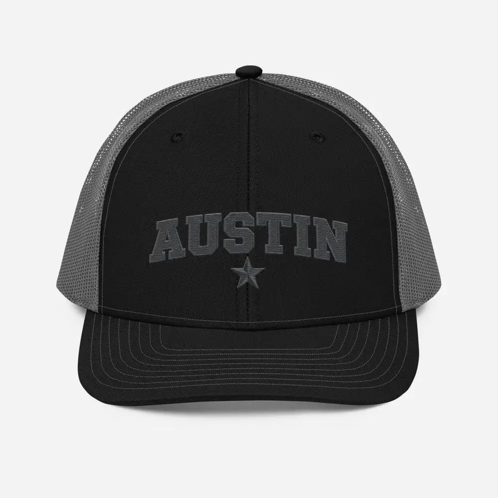 Black trucker hat with Austin Texas embroidered star design and gray mesh back