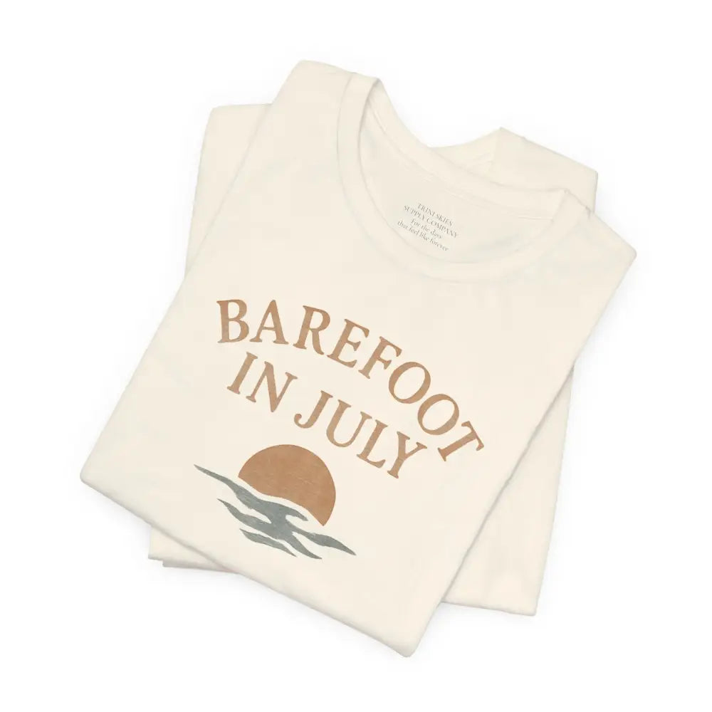 Folded cream-colored Barefoot in July vintage tee with graphic from Trini Skies Supply