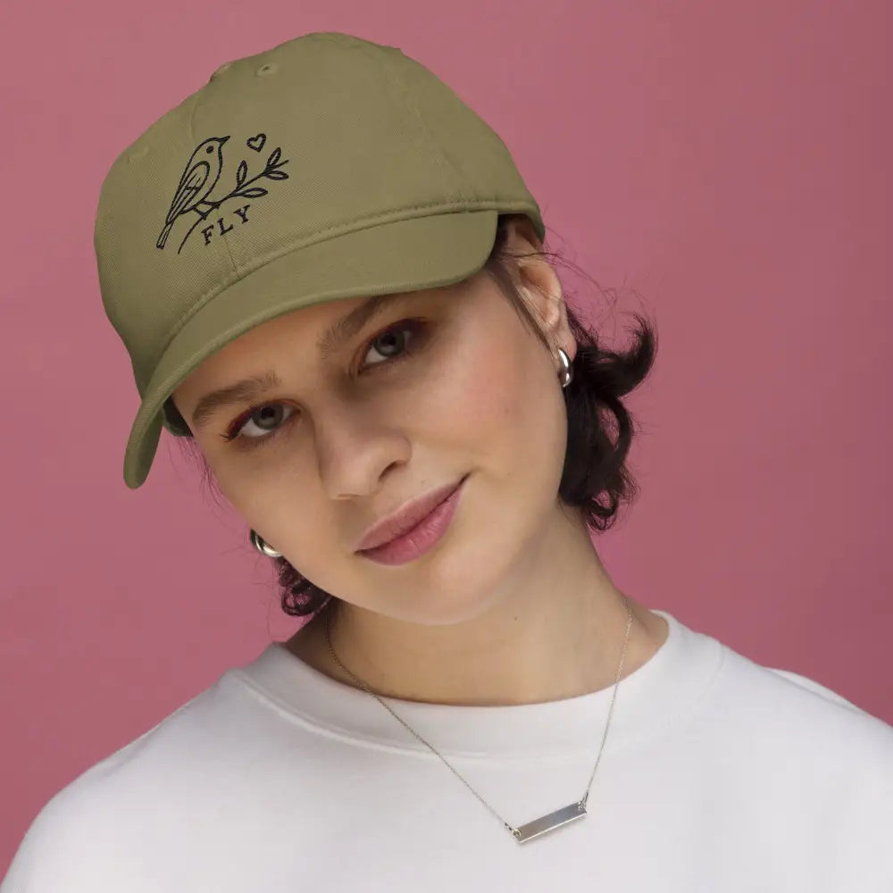 Woman in olive green Trini Skies embroidered cotton dad hat with bird branch design