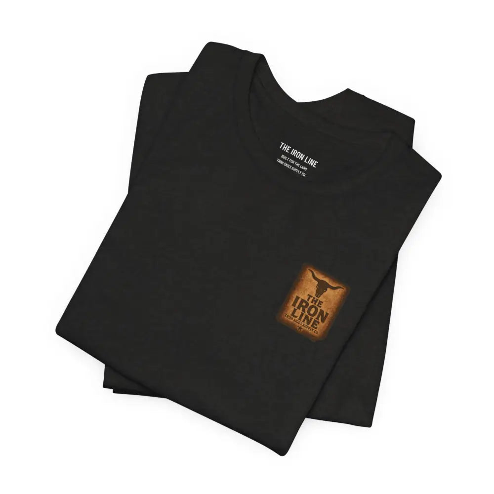 Black short-sleeved T-shirt with brown branded patch and white chest text by Trini Skies Supply