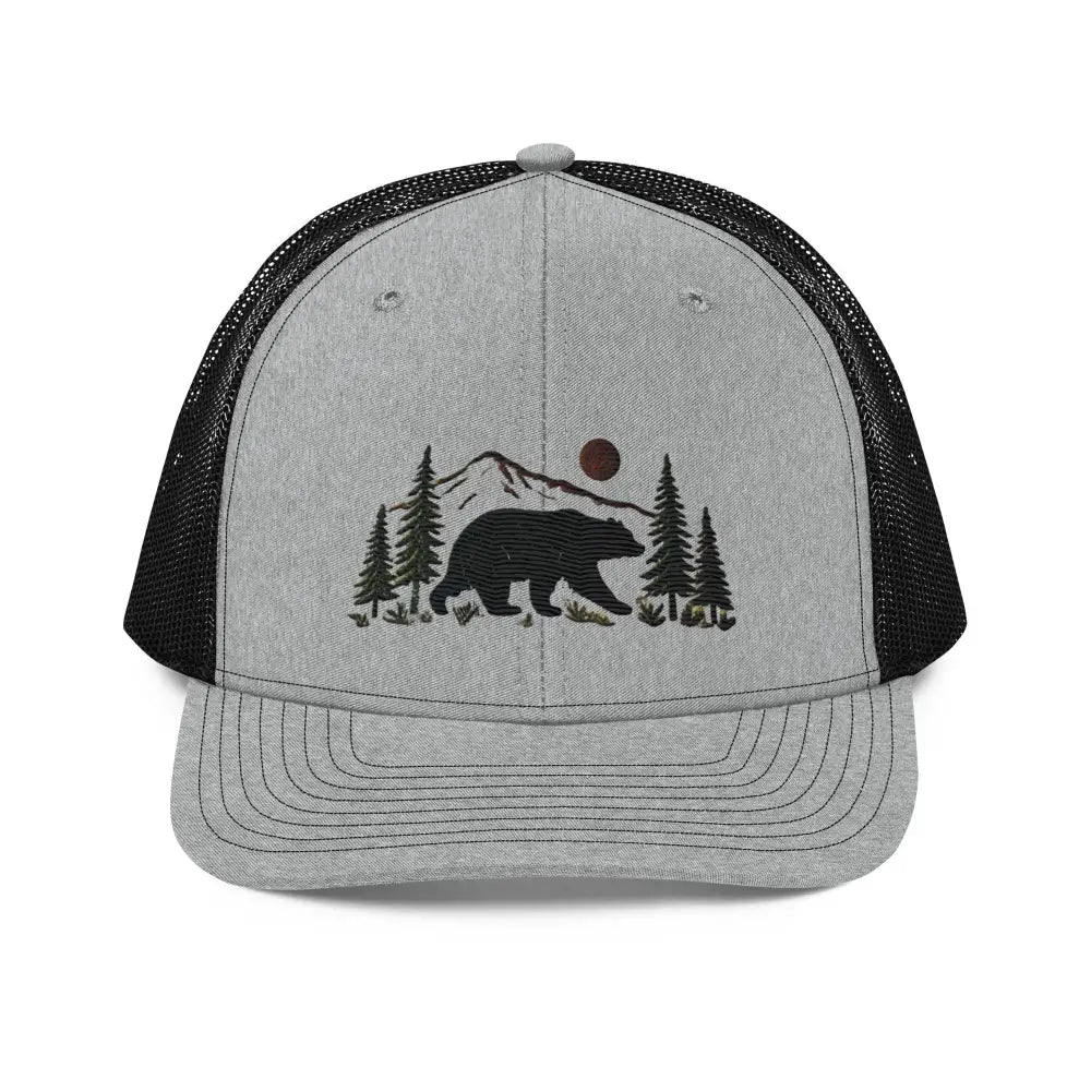 Embroidered black bear wildlife trucker cap with pine trees and mountains
