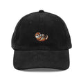 Black corduroy cap with embroidered playful otter holding heart rock by Trini Skies
