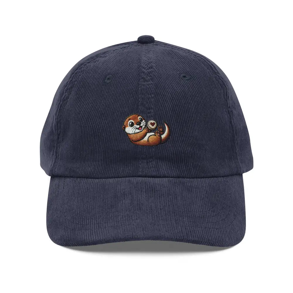 Navy blue corduroy cap with embroidered playful otter holding heart rock by Trini Skies