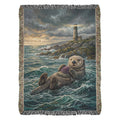 Floating sea otter with lighthouse on coastal woven cotton blanket