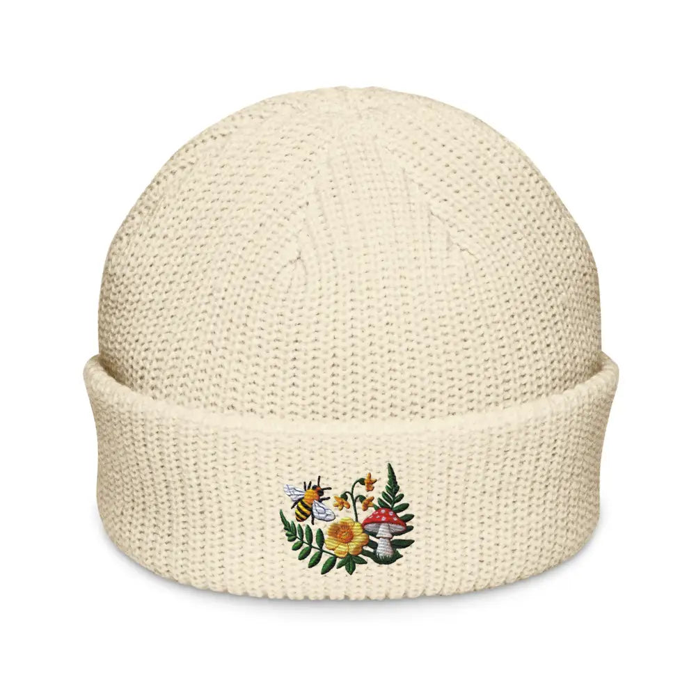 Cream-colored knitted beanie with flowered mushroom garden and embroidered bee fisherman design
