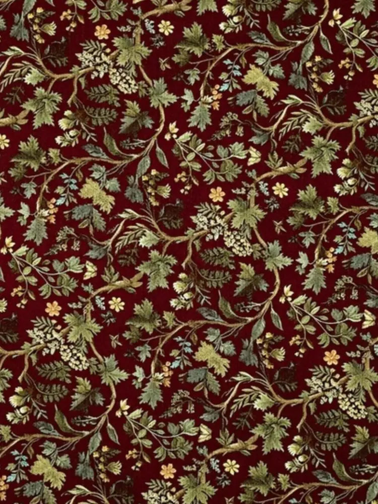 Heritage harvest woven throw blanket with botanical woodland tapestry in deep red fabric and intricate green, yellow, brown patterns