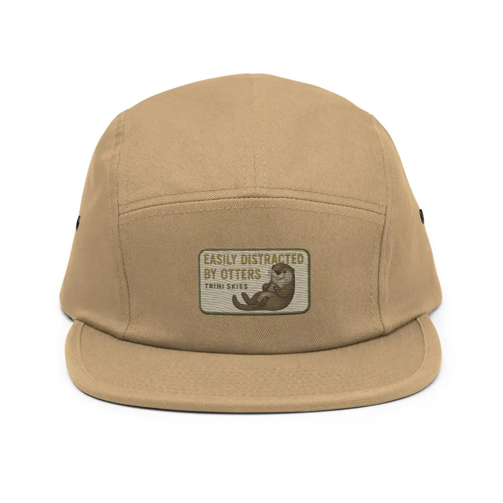 Tan five-panel cap with embroidered otter patch and nylon strap clip
