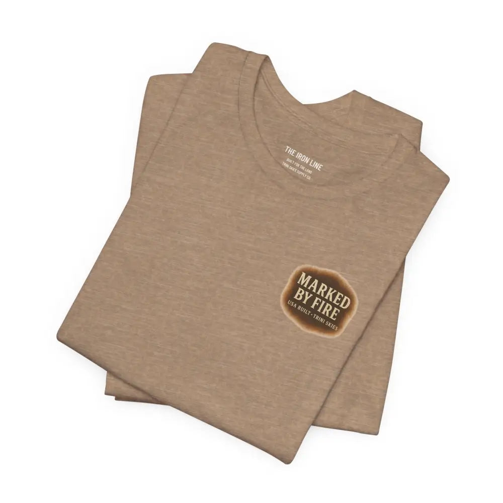 Folded tan short-sleeve T-shirt with Marked by Fire graphic from Trini Skies Supply, USA built western style